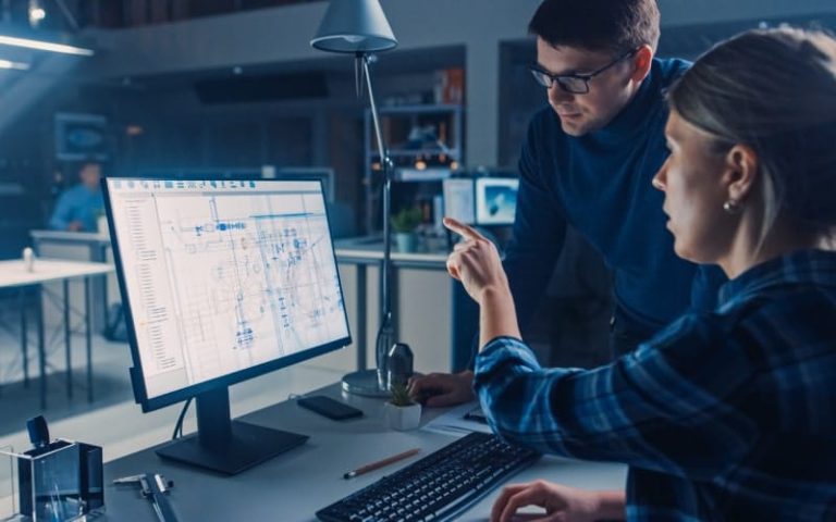 Two people discussing computer screen data.