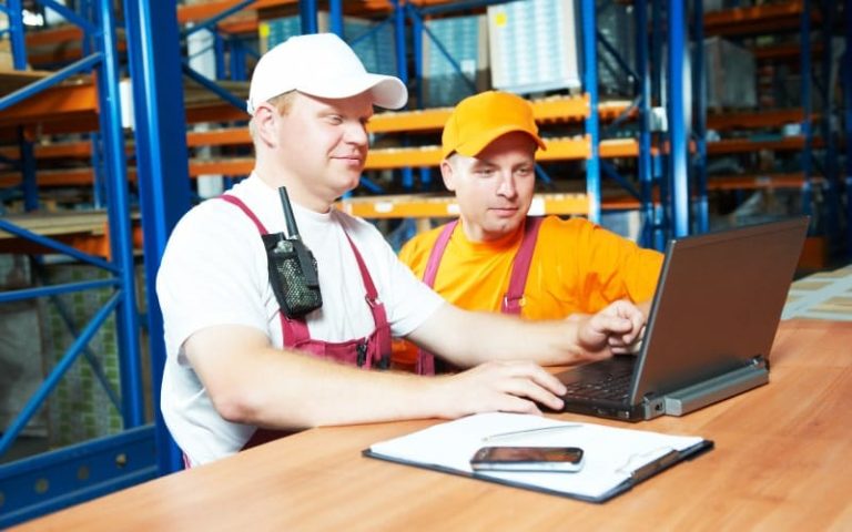 Two workers using a laptop together.