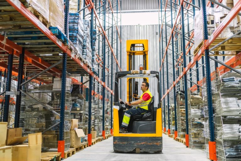 Forklift operating in a warehouse aisle.