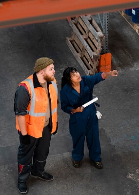 Two workers discussing in warehouse