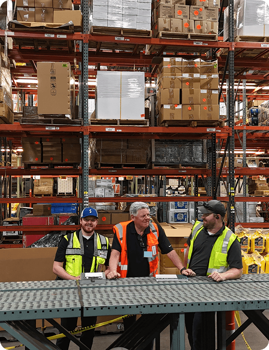 Workers collaborating in a warehouse setting.