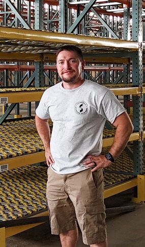Man standing in warehouse aisle.