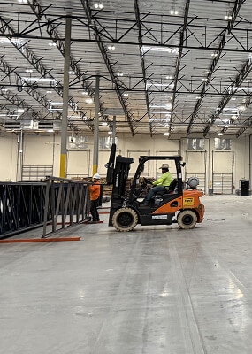 Forklift moving equipment in warehouse