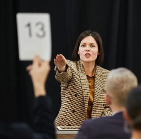 Auctioneer signaling bid number thirteen