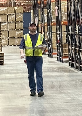 Worker in warehouse with clipboard