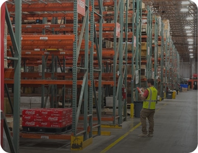 Warehouse worker inspecting inventory shelves