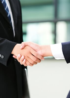 Two people shaking hands formally.