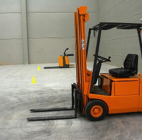 Forklift in empty warehouse space.