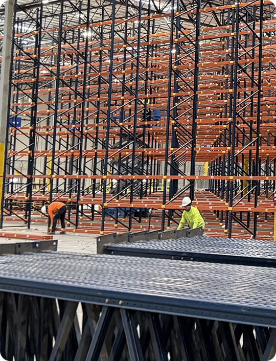 Workers assembling industrial shelving units.