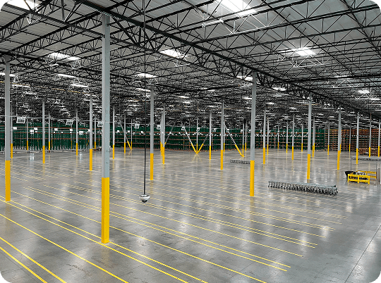 Spacious, empty warehouse with yellow lines.