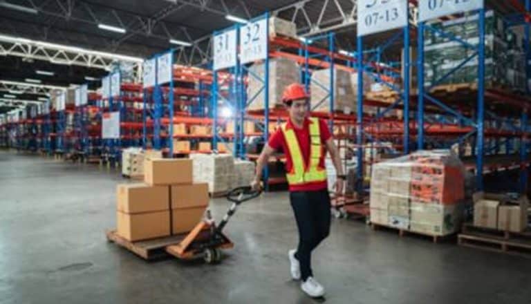 Warehouse worker moving boxes on pallet