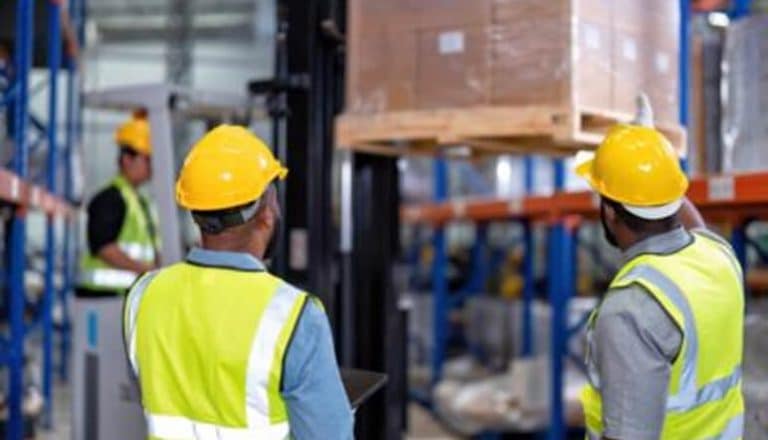 Workers operating a forklift in warehouse