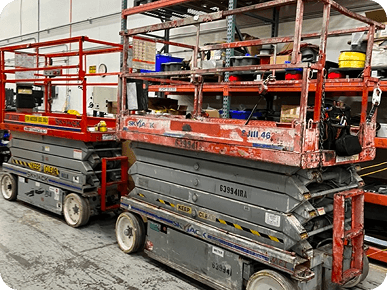 Two scissor lifts in warehouse