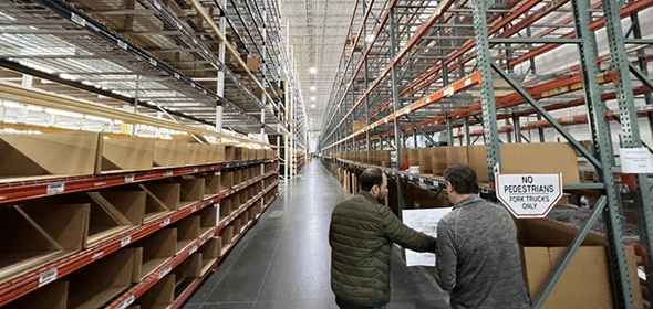 Two people discussing in warehouse aisle